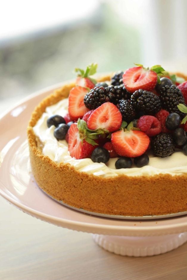 No-Bake Cheesecake Recipe served on a light pink cake stand