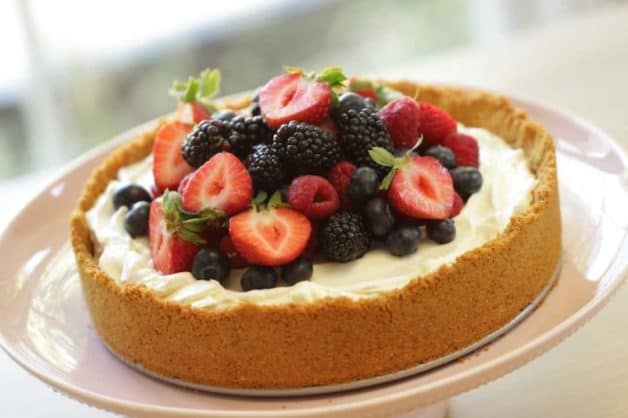 No-Bake Cheesecake Recipe served on a light pink cake stand