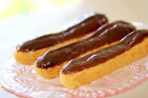 Chocolate Eclairs served on a pink glass cake stand 