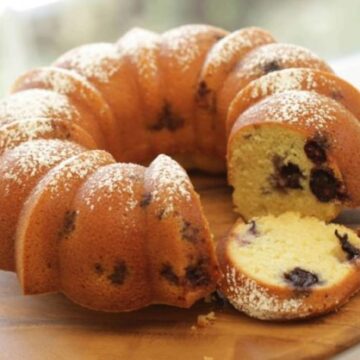 Blueberry Lemon Bundt Cake Recipe served on a wood platter with a slice cut out of