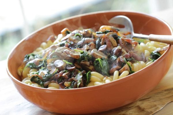 Pasta with Sautéed Veggies in a large dark orange bowl with a silver spoon 