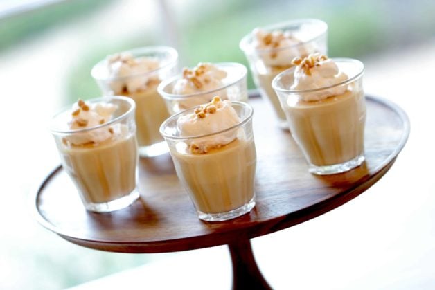 A cup of coffee on a table, with Caramel and Pudding