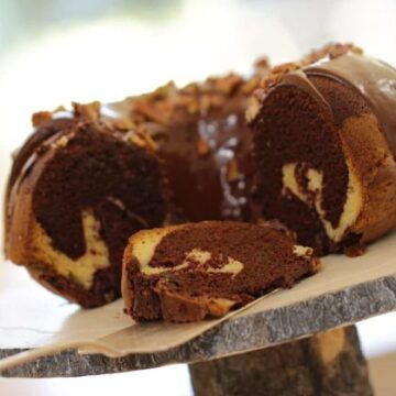 Chocolate Marble Cake Recipe on a wooden cake stand sliced open to see swirls