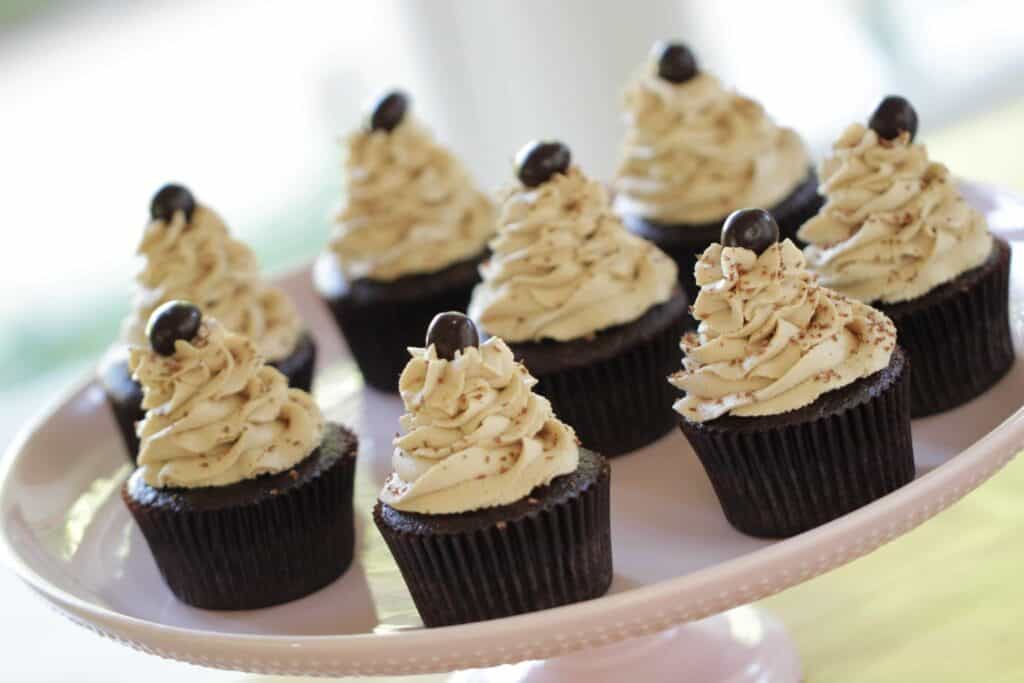 Cafe Mocha Cupcakes topped with espresso bean garnishes on a pink cakestand