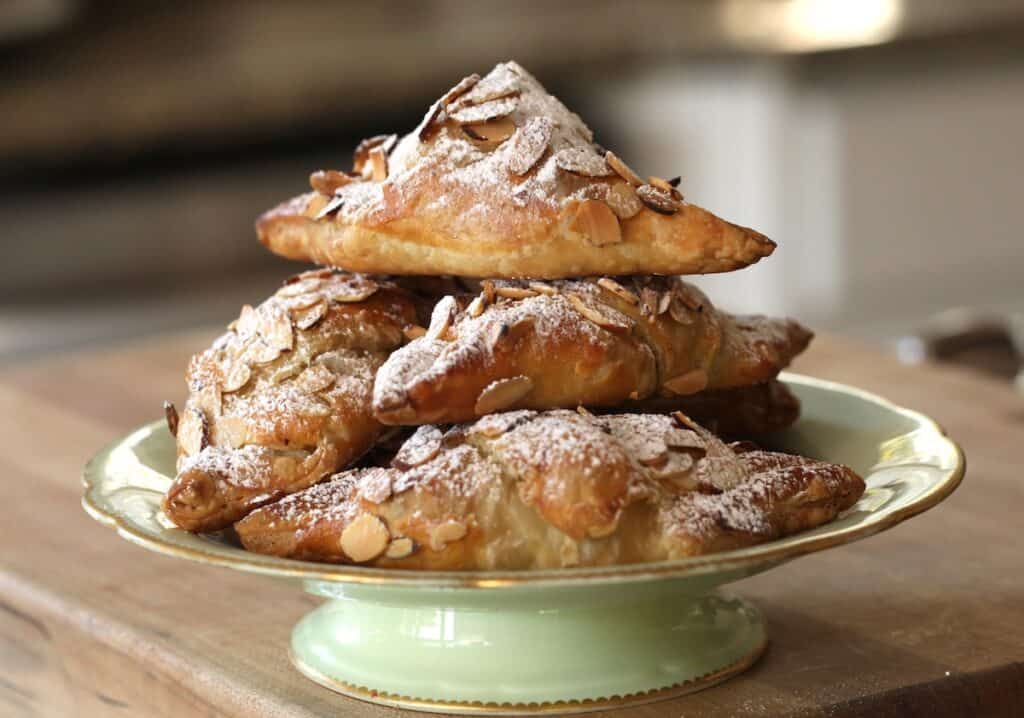 Almond Croissants piled high on a green cake stand