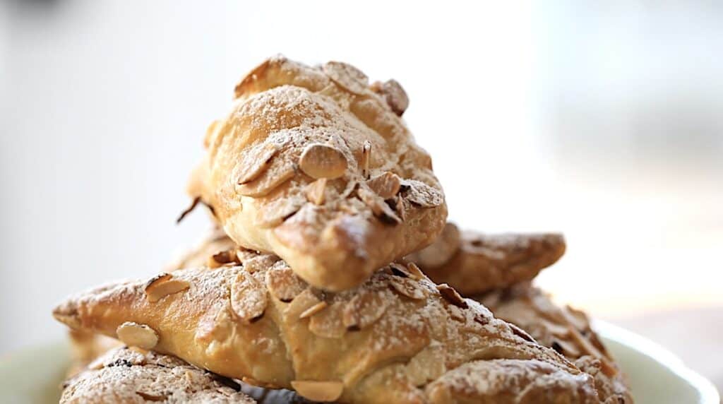 close up of croissants dusted with powdered sugar