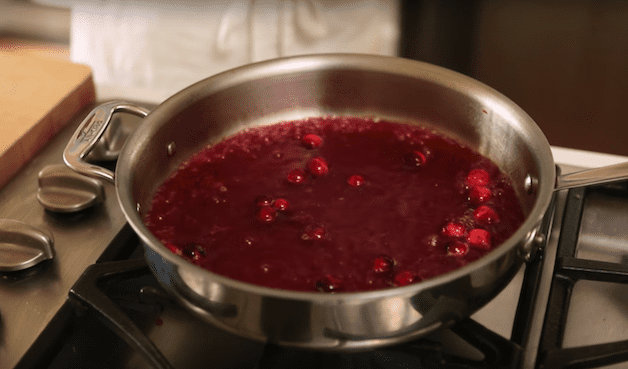 cranberry sauce cooking on the stove for a Cranberry Panna Cotta Recipe