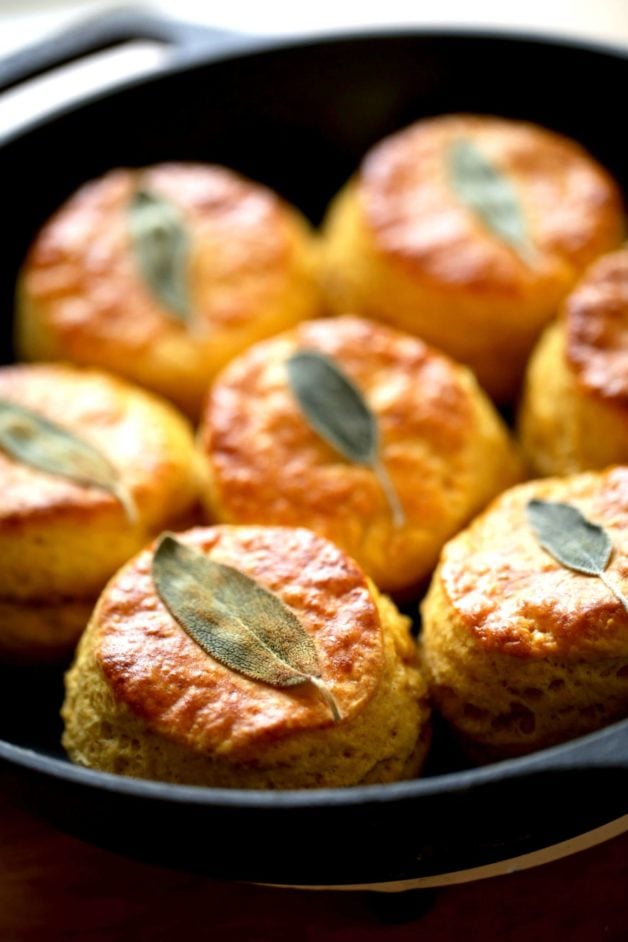 Sweet Potato Biscuits with a sage leaf on top baked in a cast iron skillet