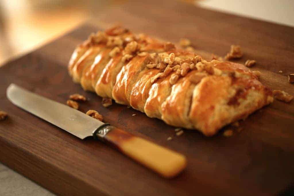 Fig and Brie Braid in Puff Pastry on a Walnut Board with a Knife