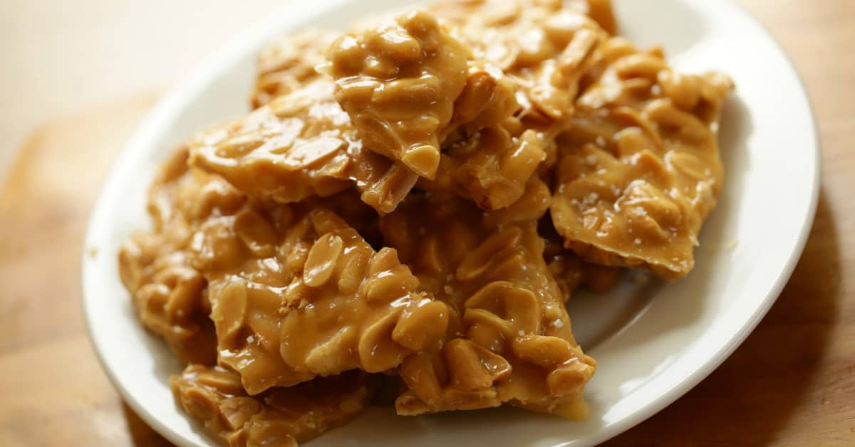 Shards of Peanut Brittle on a white plate