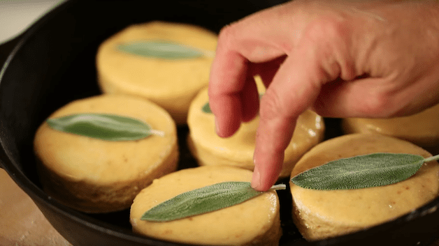 sage leaves being pressed on top of a biscuit