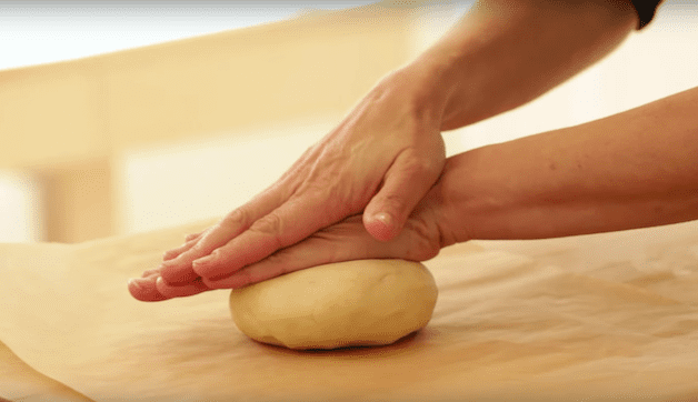 tart dough being rolled on a wood board 