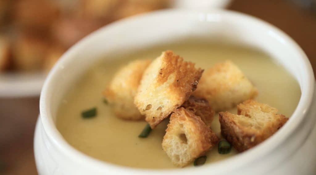 Potato Leek soup in white bowl with croutons