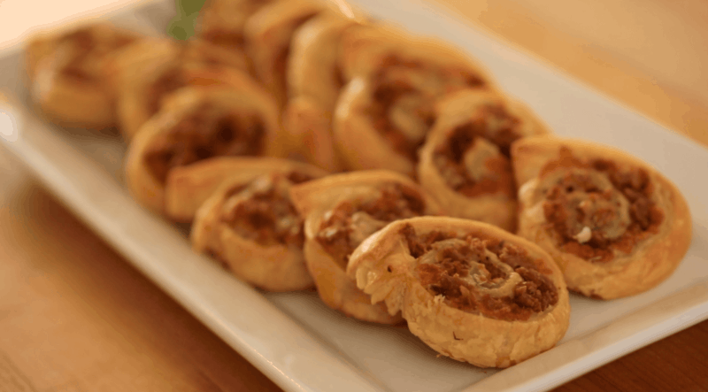 Freshly Baked Pinwheels with sausage and cheese on a rectangular platter