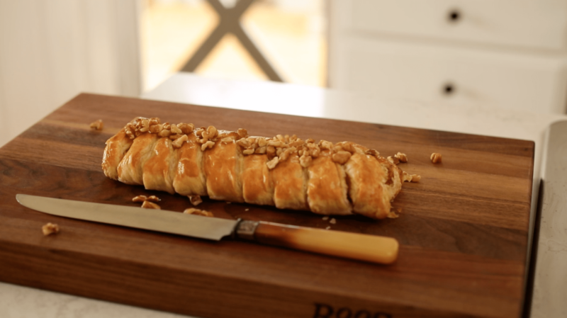 A Brie and Fig Braid fresh from the oven on a walnut cutting board