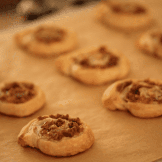 Freshly Baked Sausage and Cheese Pinwheels on a baking sheet lined with parchment paper