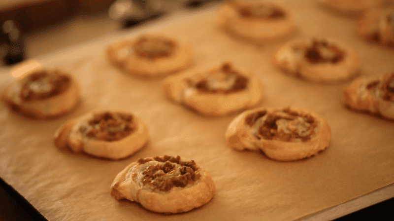 Freshly Baked Sausage and Cheese Pinwheels on a baking sheet lined with parchment paper