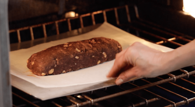Chocolate Hazelnut Biscotti log being baked in the oven on a cookie tray