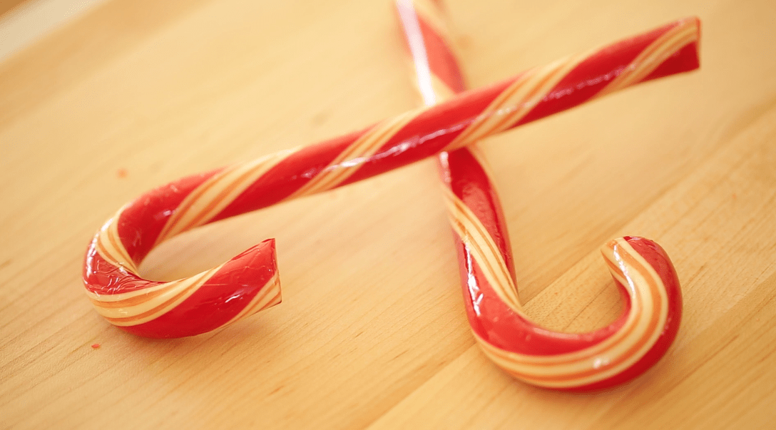 Two Gourmet Candy Canes, criss crossed together on a cutting board