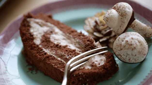 A fork taking a bite of a slice of yule log with chocolate hazelnut cream 