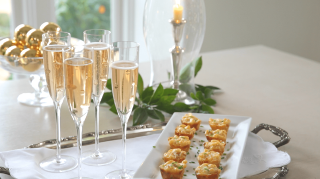 Bacon Mac & Cheese Bites on a platter with glasses of champagne 