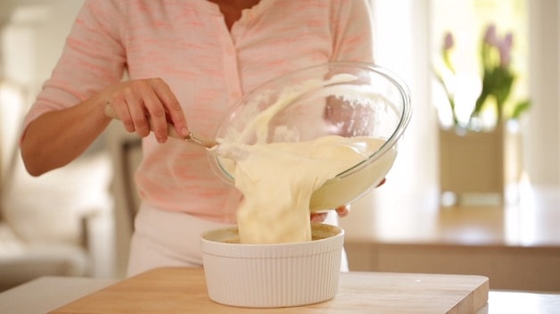 pouring a cheese souffle batter into a souffle dish