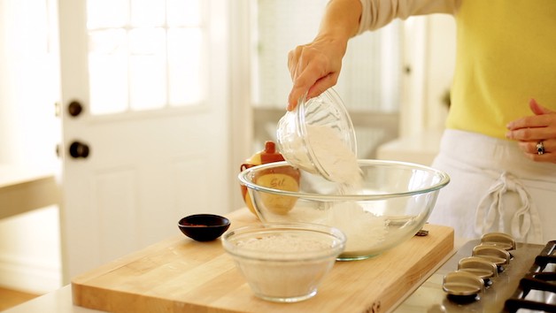 Adding flour to a large mixing bowl