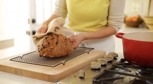 Placing Freshly Baked No Knead Cinnamon Bread on cooling rack