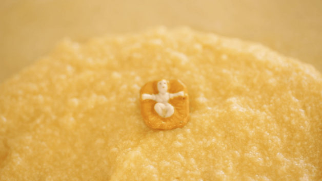 Baby Jesus Feve nestled in almond paste in a galette de rois cake