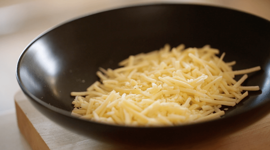 Shredded Gruyere cheese in a black bowl