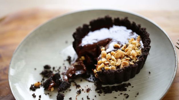 Chocolate Hazelnut Tart on a gray plate with bite taken out of it