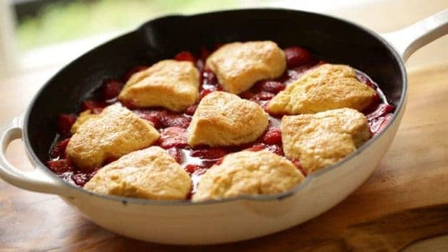 freshly baked strawberry cobbler in a white skillet on a table