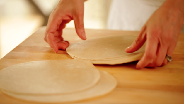 tortillas being prepared on a wood surface for a Veggie Quesadilla Recipe with Chunky Gaucomole