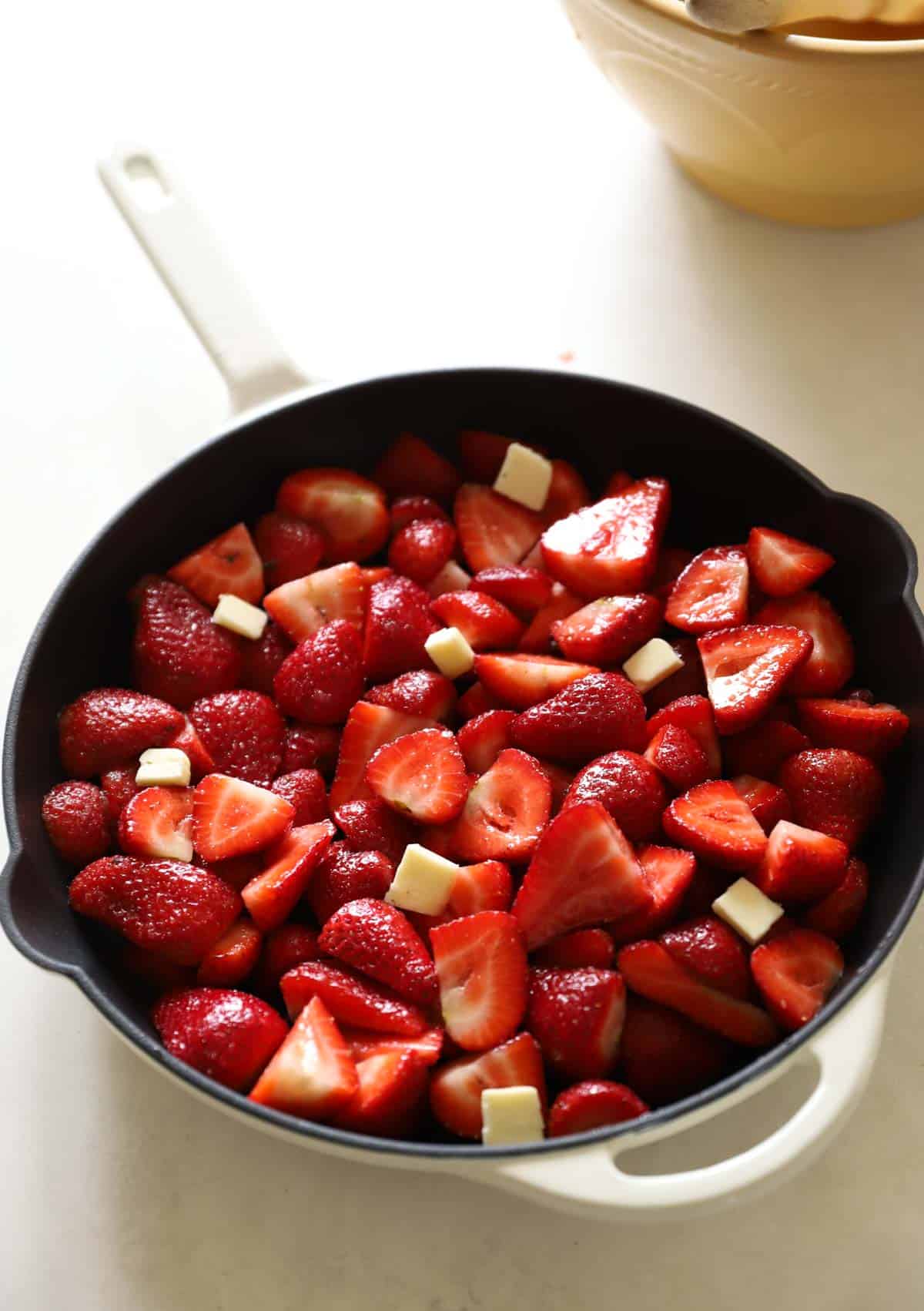 strawberries in a cast-iron skillet with butter on top