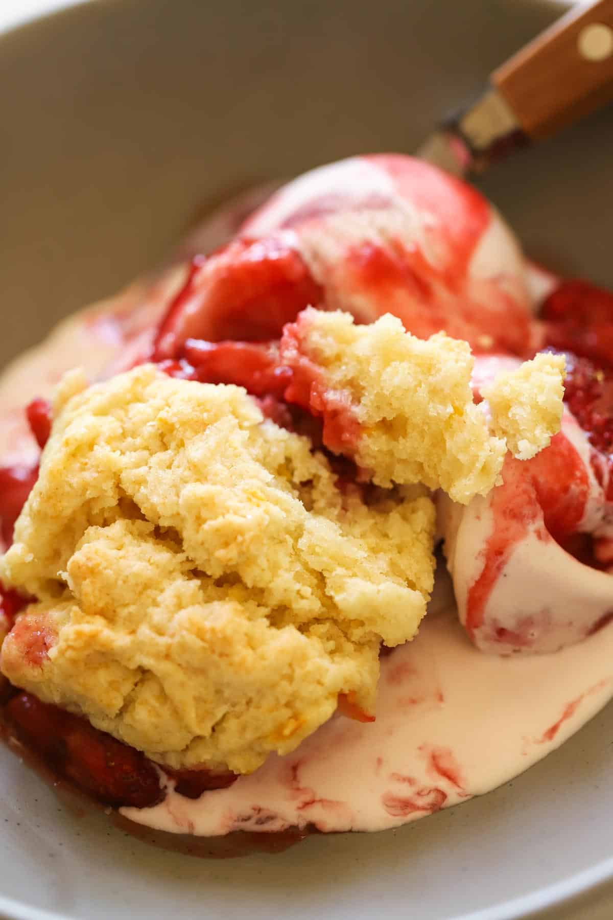 a bowl of strawberry cobbler with a flakey drop biscuit