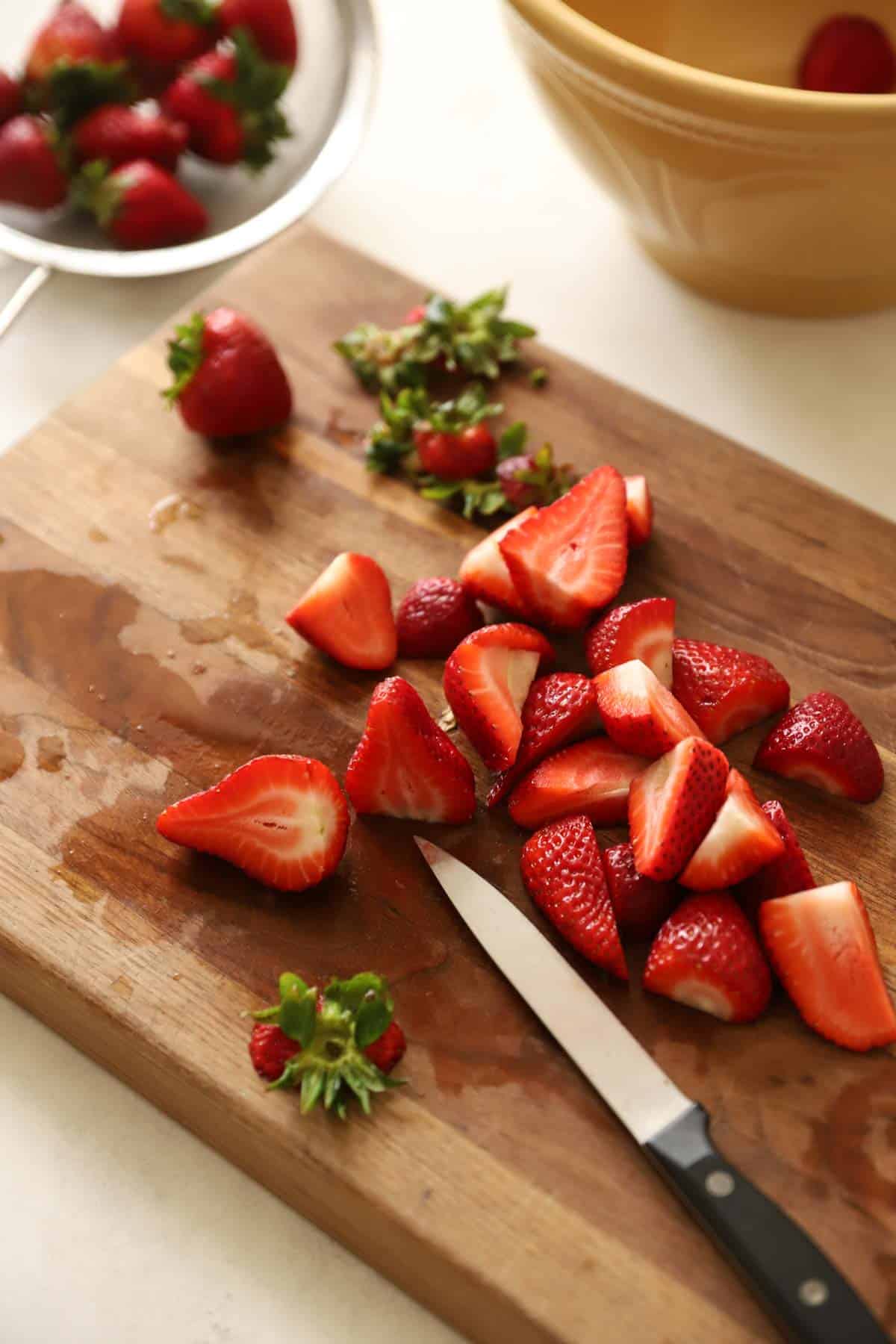 slicing strawberries on a cutting board