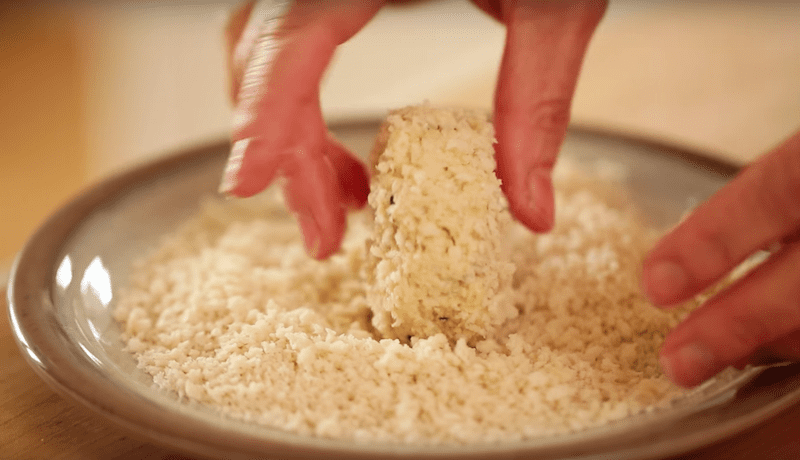 crab cakes being rolled in bread crumbs for an easy crab crake recipe