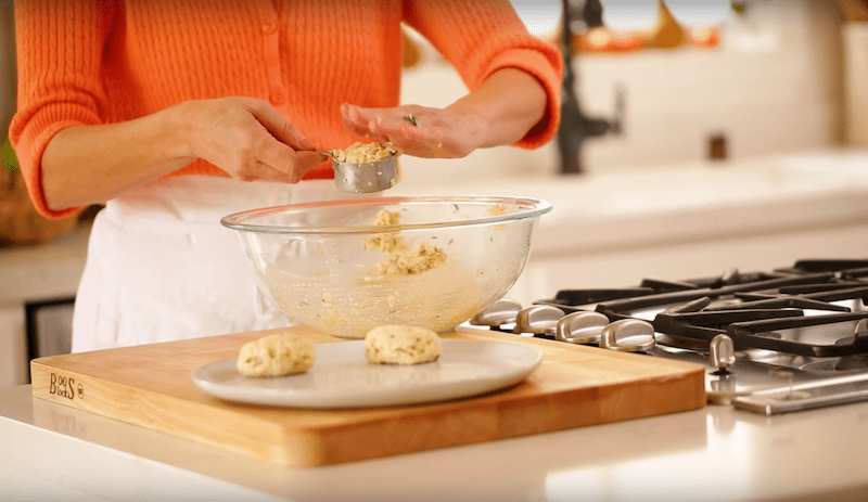 crab cakes being measured into a silver cup for an easy crab cake recipe