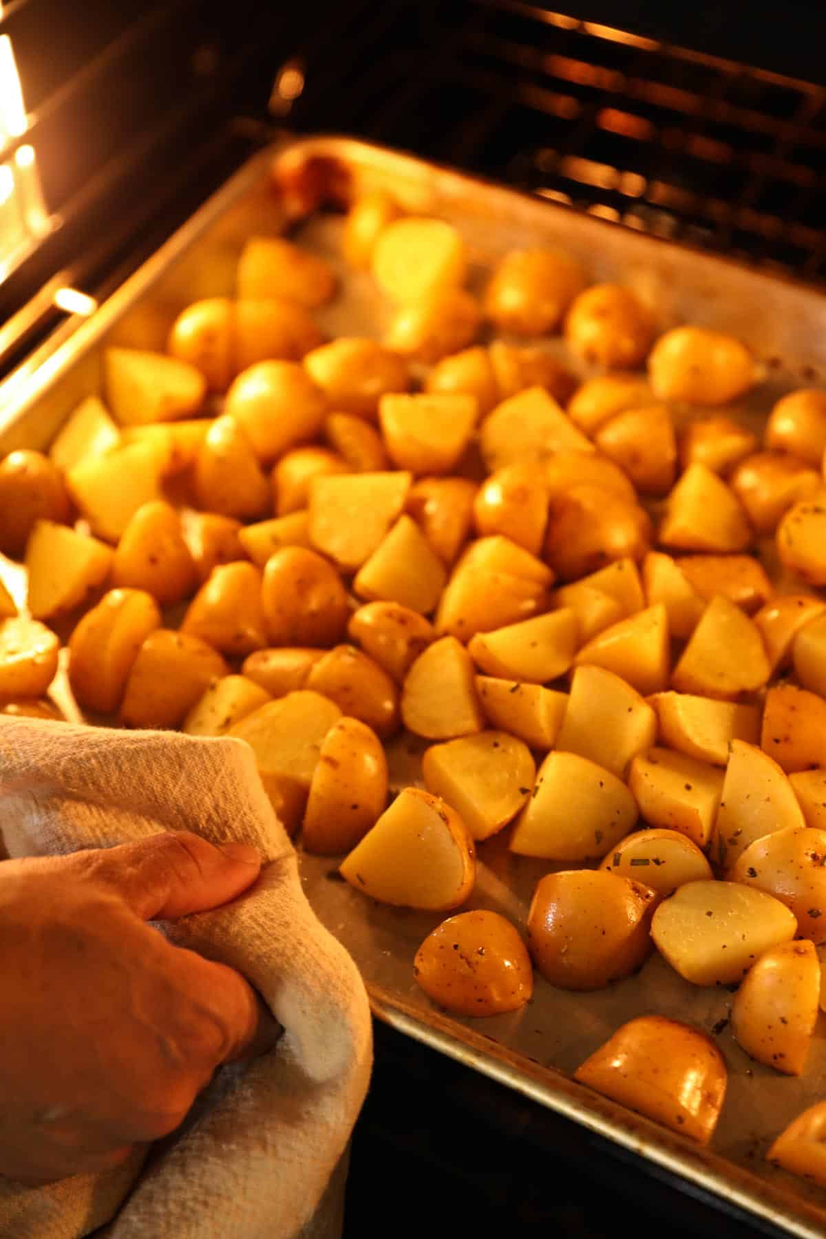 shaking potatoes in an oven