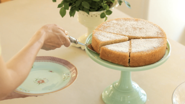 Orange Almond Cake on a green cake stand being served