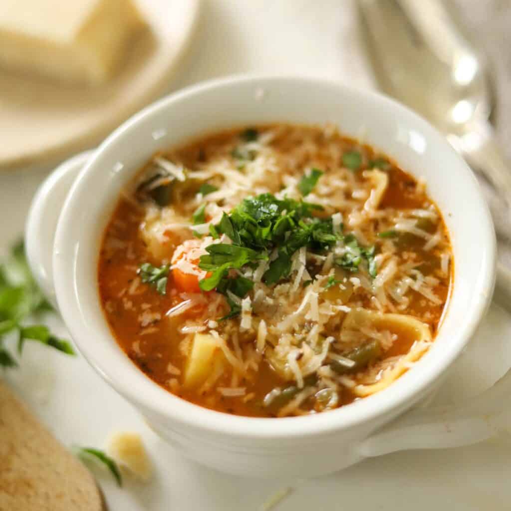 Closeup of Minestrone soup topped with freshly grated Parmesan cheese.