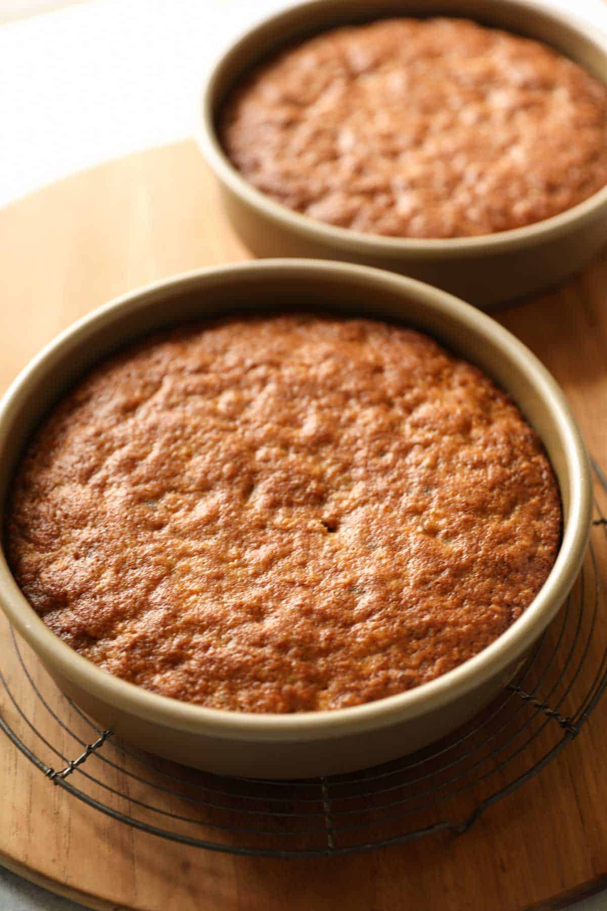 homemade carrot cake cooling in pans on cutting board