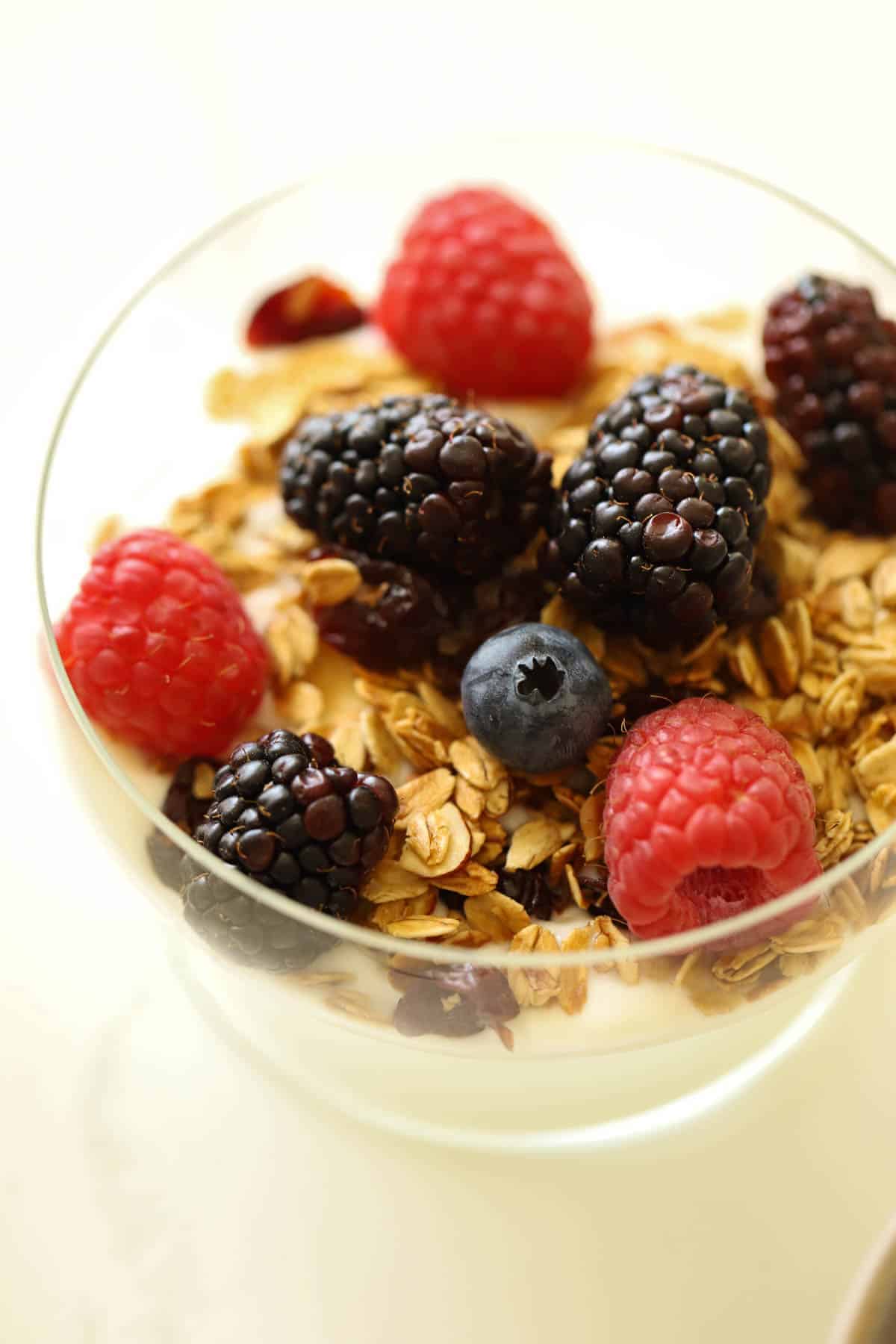 a yogurt parfait with fresh berries in a clear bowl