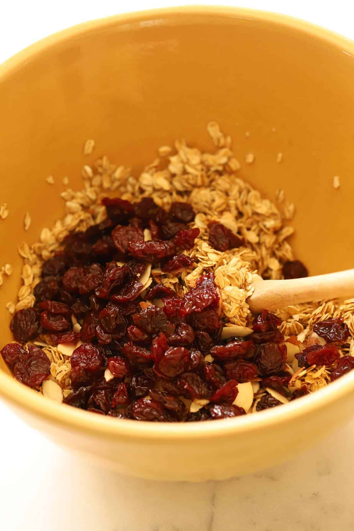 Oats and cherries in a bowl being mixed