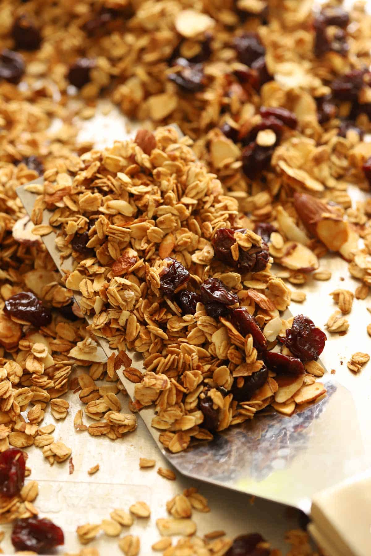 a spatula lifting cool granola on a pan