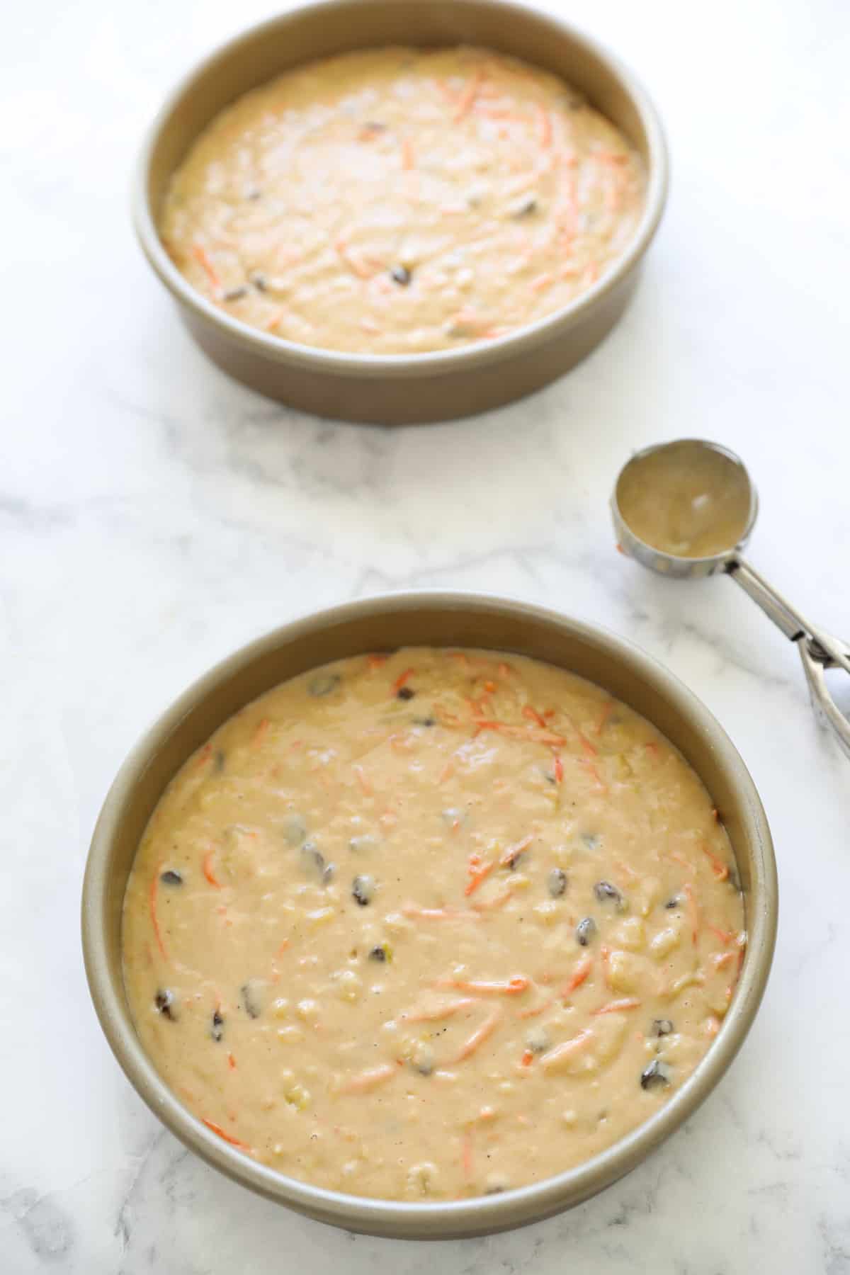 Cake batter in cake pan with an ice cream scoop