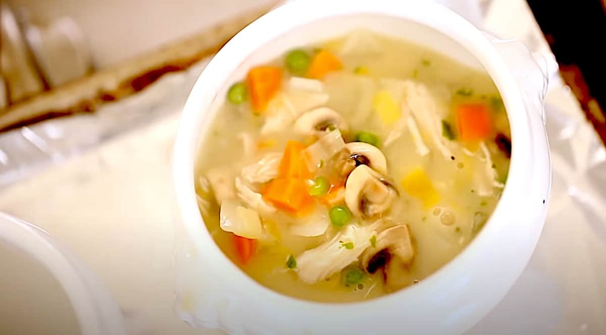 overhead shot of chicken pot pie soup in a white bowl