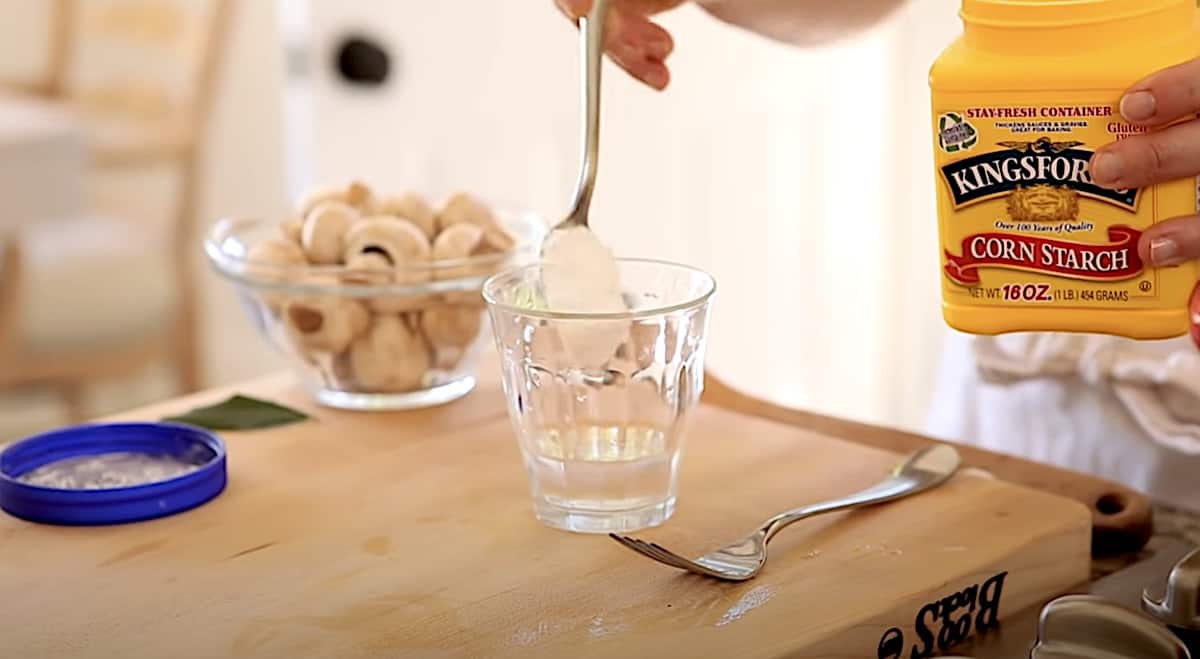 Cornstarch being placed in a glass of water