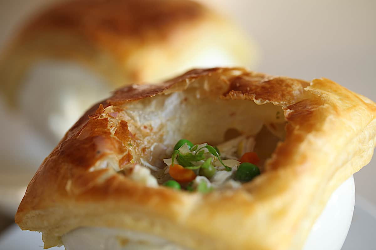 Chicken Pot Pie with puff pastry topping cut open to see filling inside