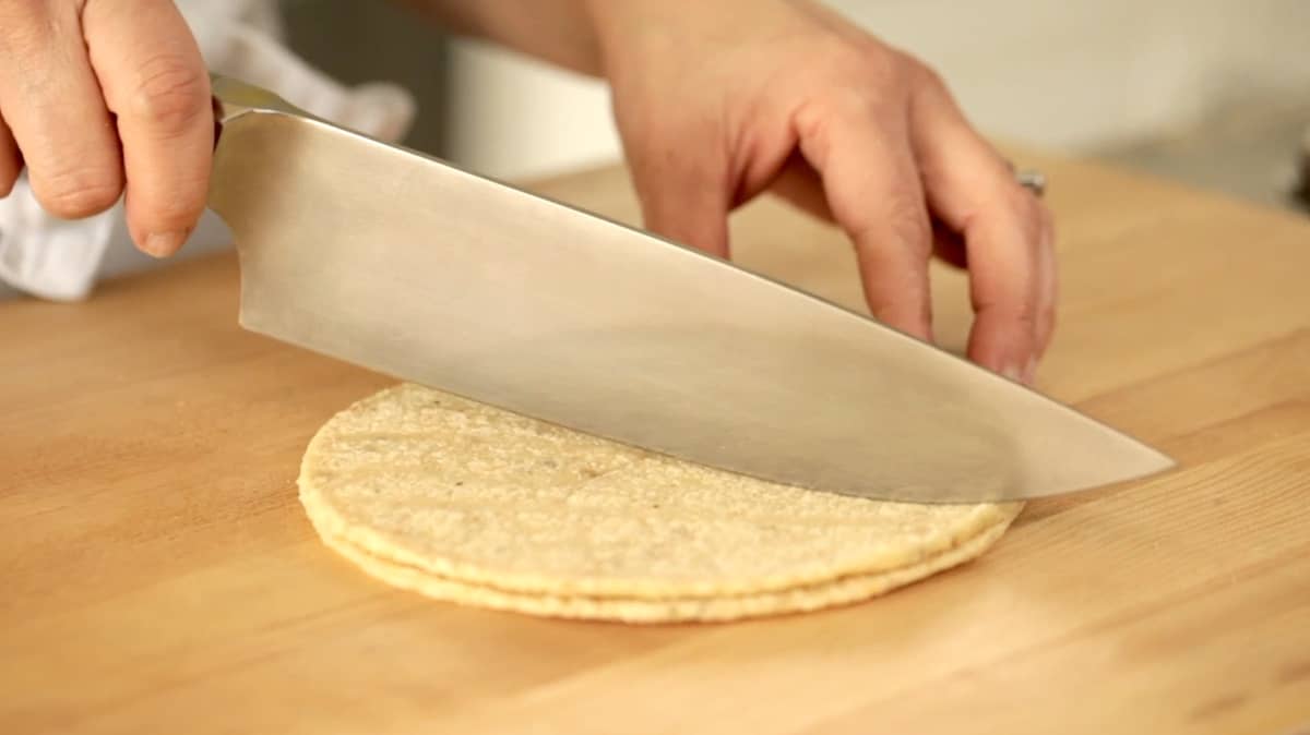 a person cutting corn tortillas